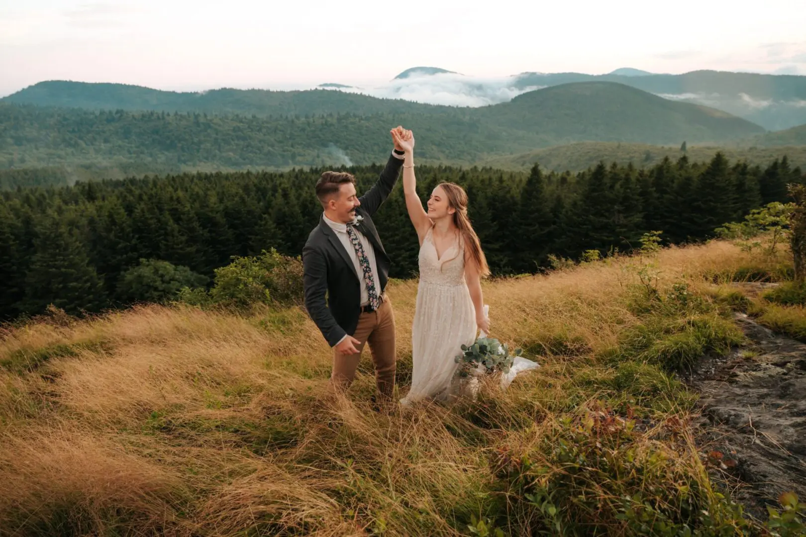 A man and woman holding hands in the grass.