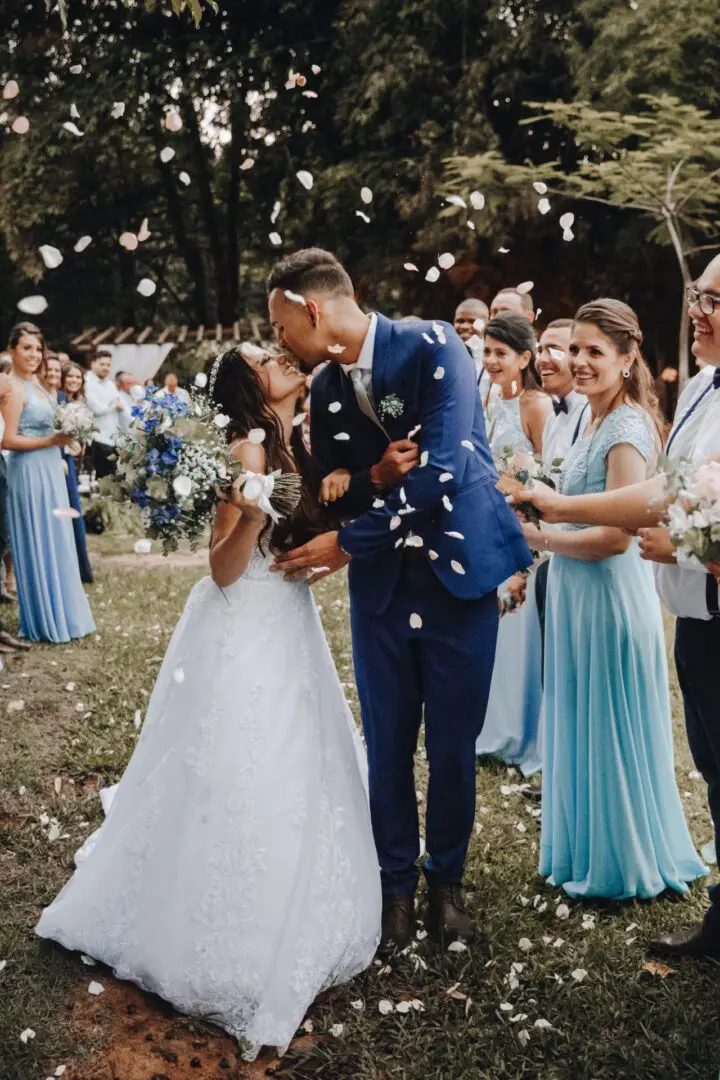 A bride and groom kissing in front of the crowd.