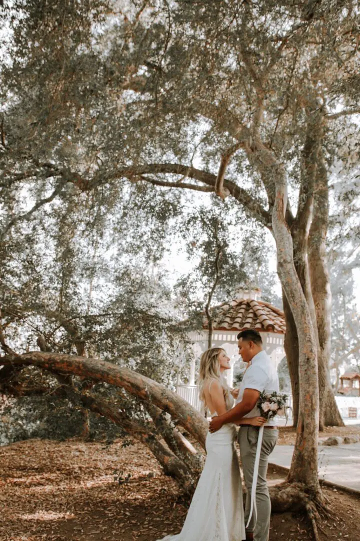 A man and woman standing under a tree.