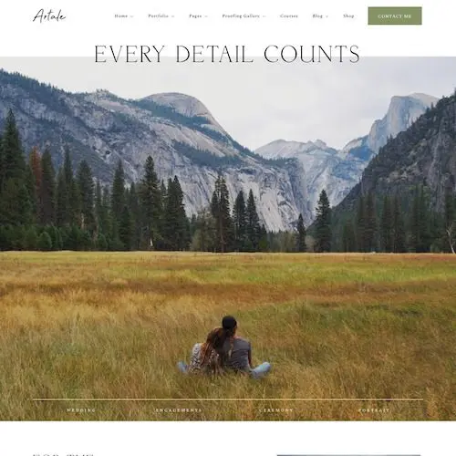 A person sitting in the grass with mountains behind them.