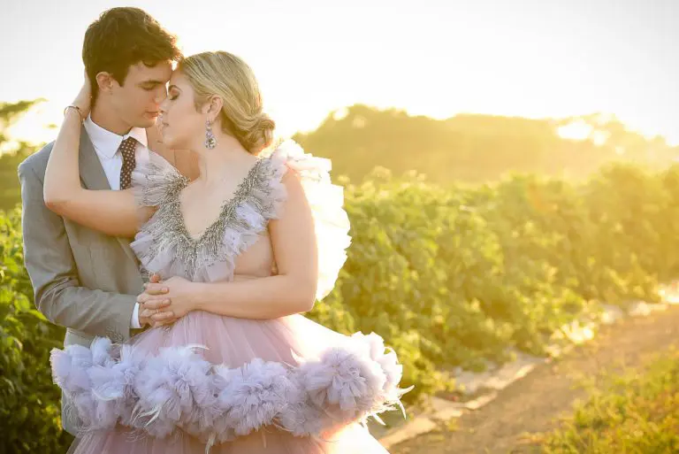 A man and woman in formal wear kissing.