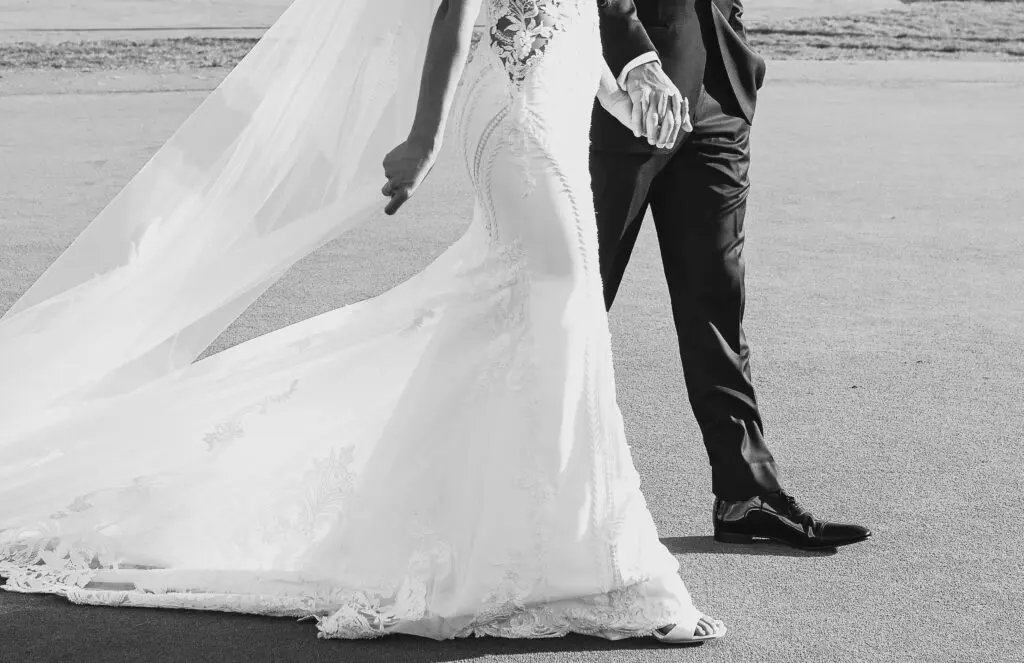 Bride and groom holding hands walking.