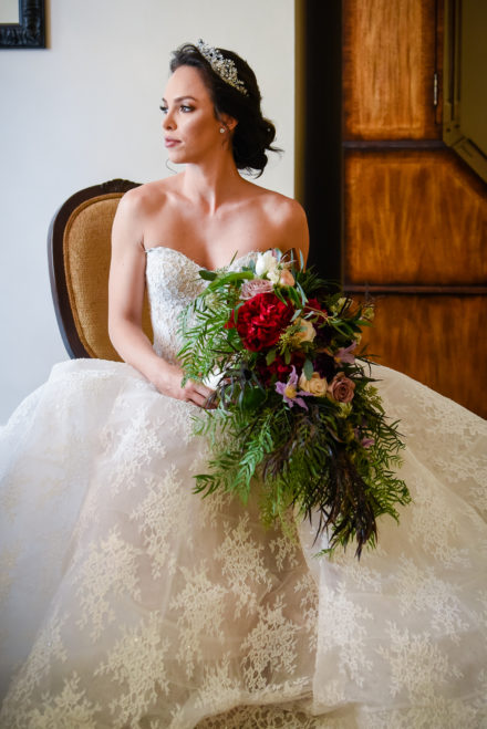 A bride holding her bouquet of flowers in front of the camera.