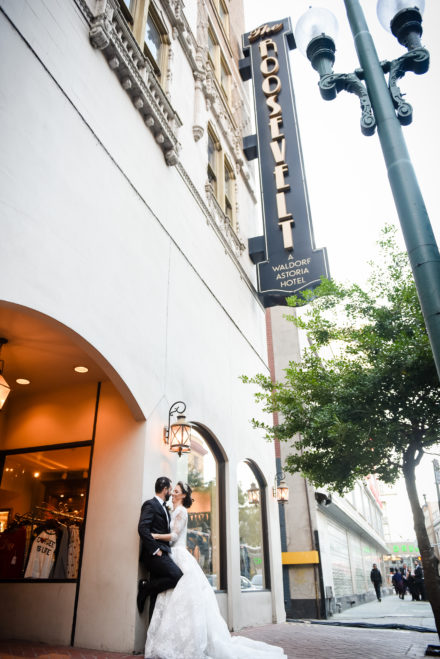 A couple standing under the street sign for hotel valet.