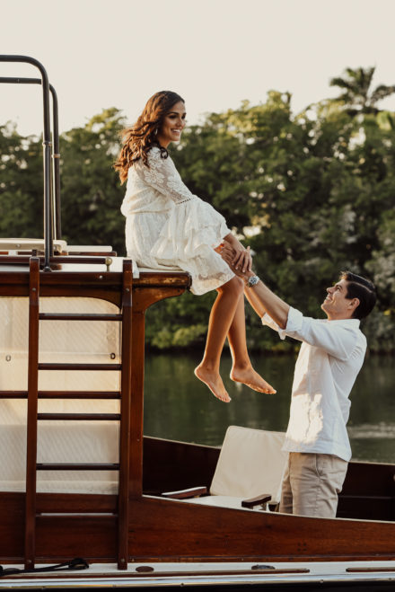 A man holding up a woman on top of a boat.