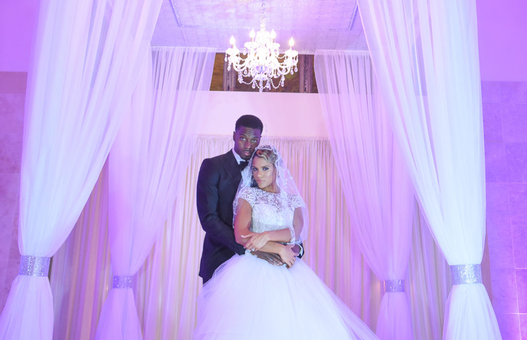 A bride and groom pose for the camera.