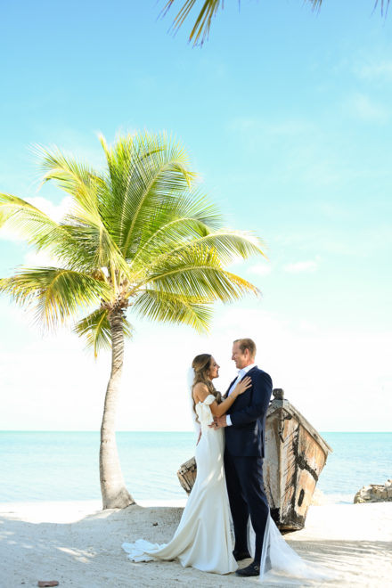 A bride and groom standing on the beach