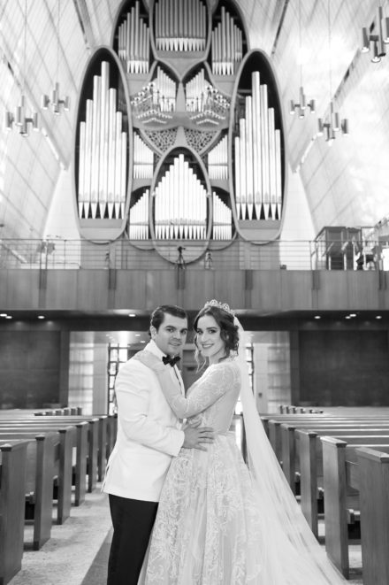 A couple posing for a picture in front of an organ.