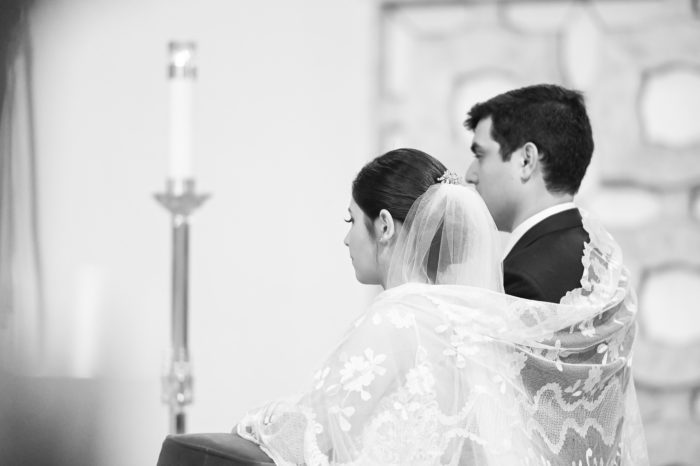 A couple is sitting in front of the alter.