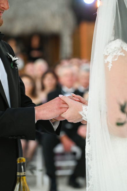 A man and woman holding hands at their wedding.
