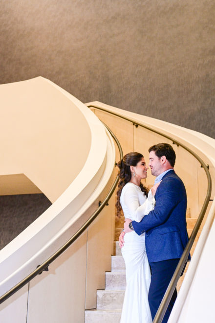 A bride and groom are standing on the stairs.