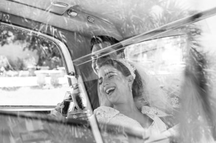 A black and white photo of two people in the back seat of a car.