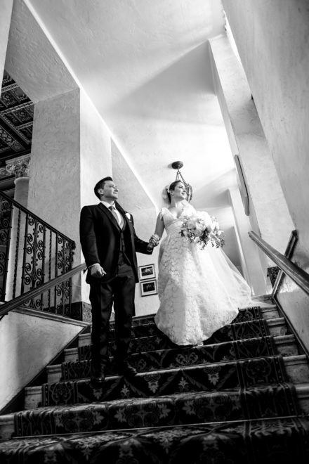 A man and woman walking up stairs holding hands.