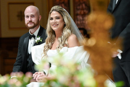 A bride and groom are smiling for the camera.