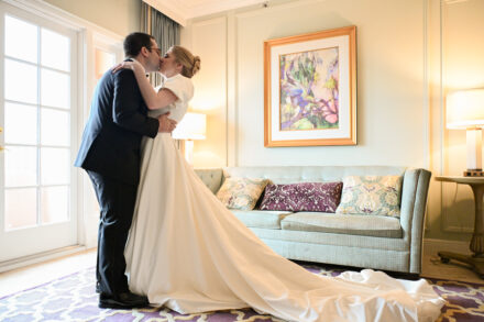 A bride and groom kissing in front of the couch