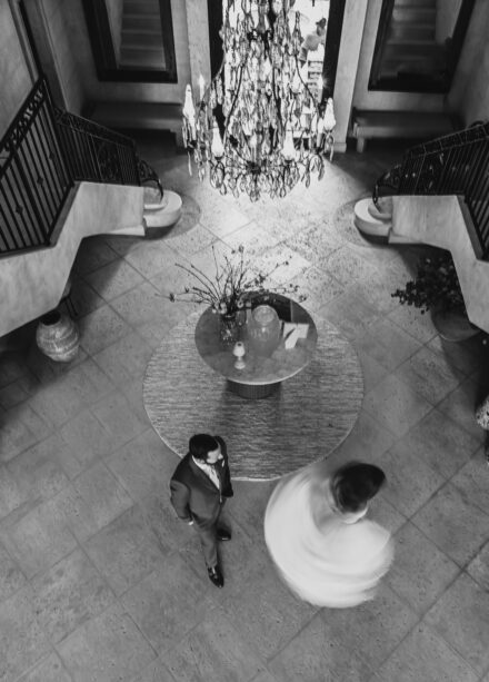 A black and white photo of two people in an atrium.