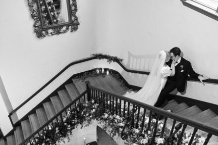 A bride and groom kissing on the stairs.