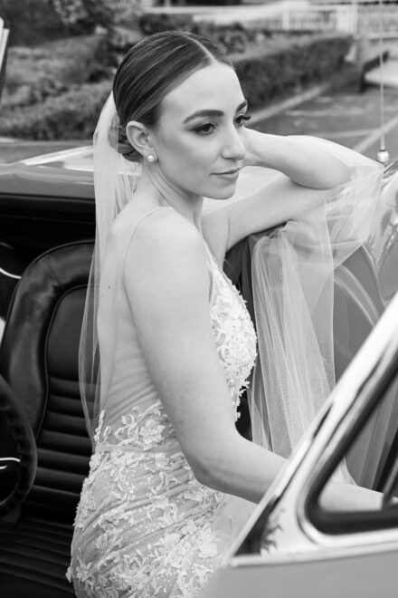 A bride in her wedding dress getting out of the car