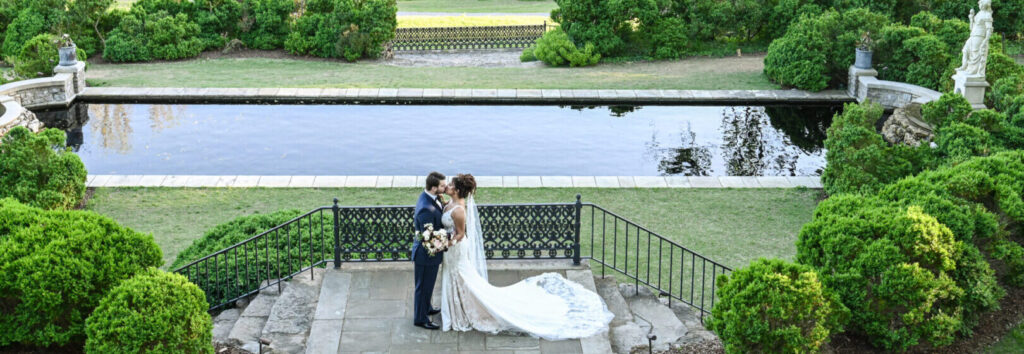Bride and groom kissing by pond.